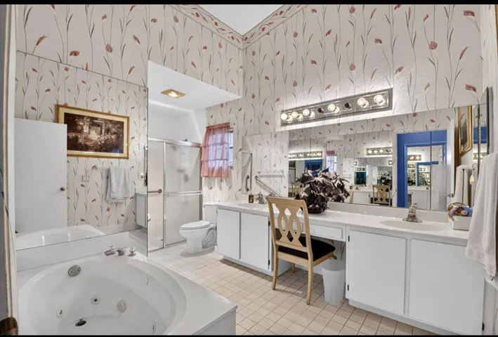 Spacious primary bath with dual vanities and soaking tub.