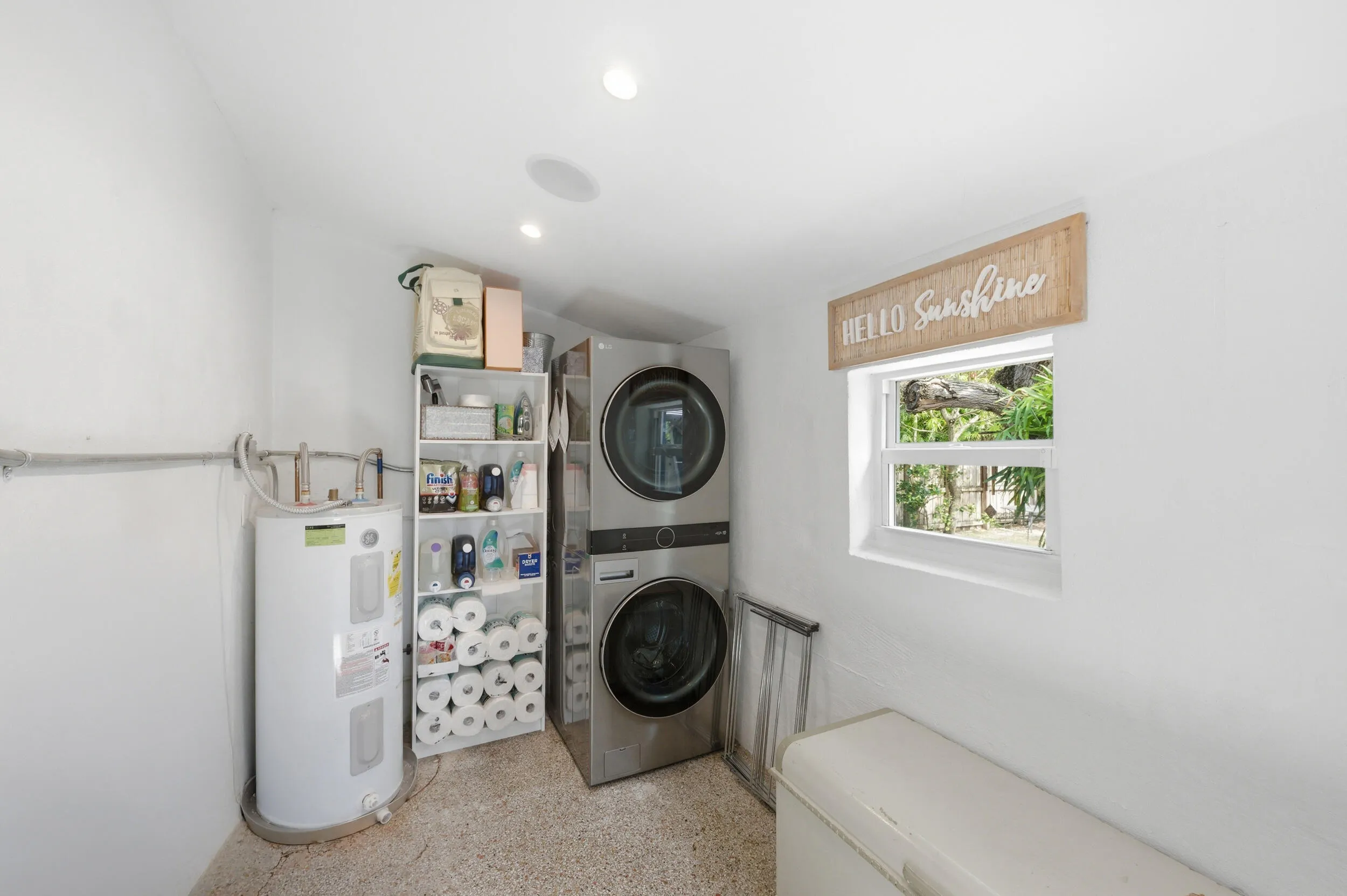 Laundry area with white walls, recessed lighting, and a window