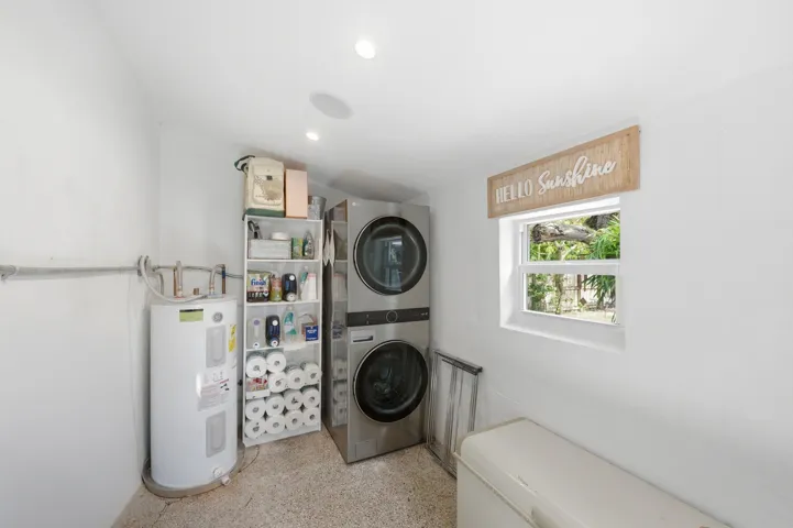 Laundry area with white walls, recessed lighting, and a window