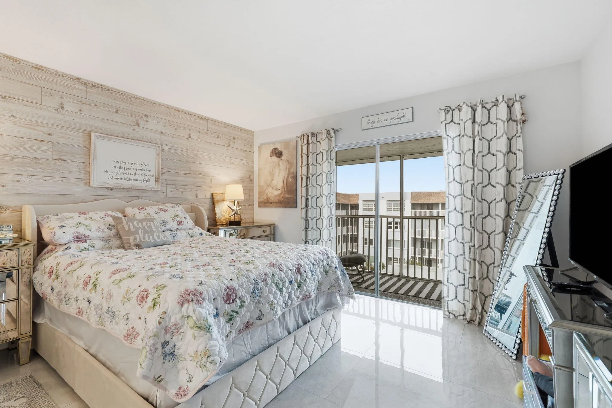 Wood-finish accent wall, white tile flooring, sliding glass door, and screened balcony