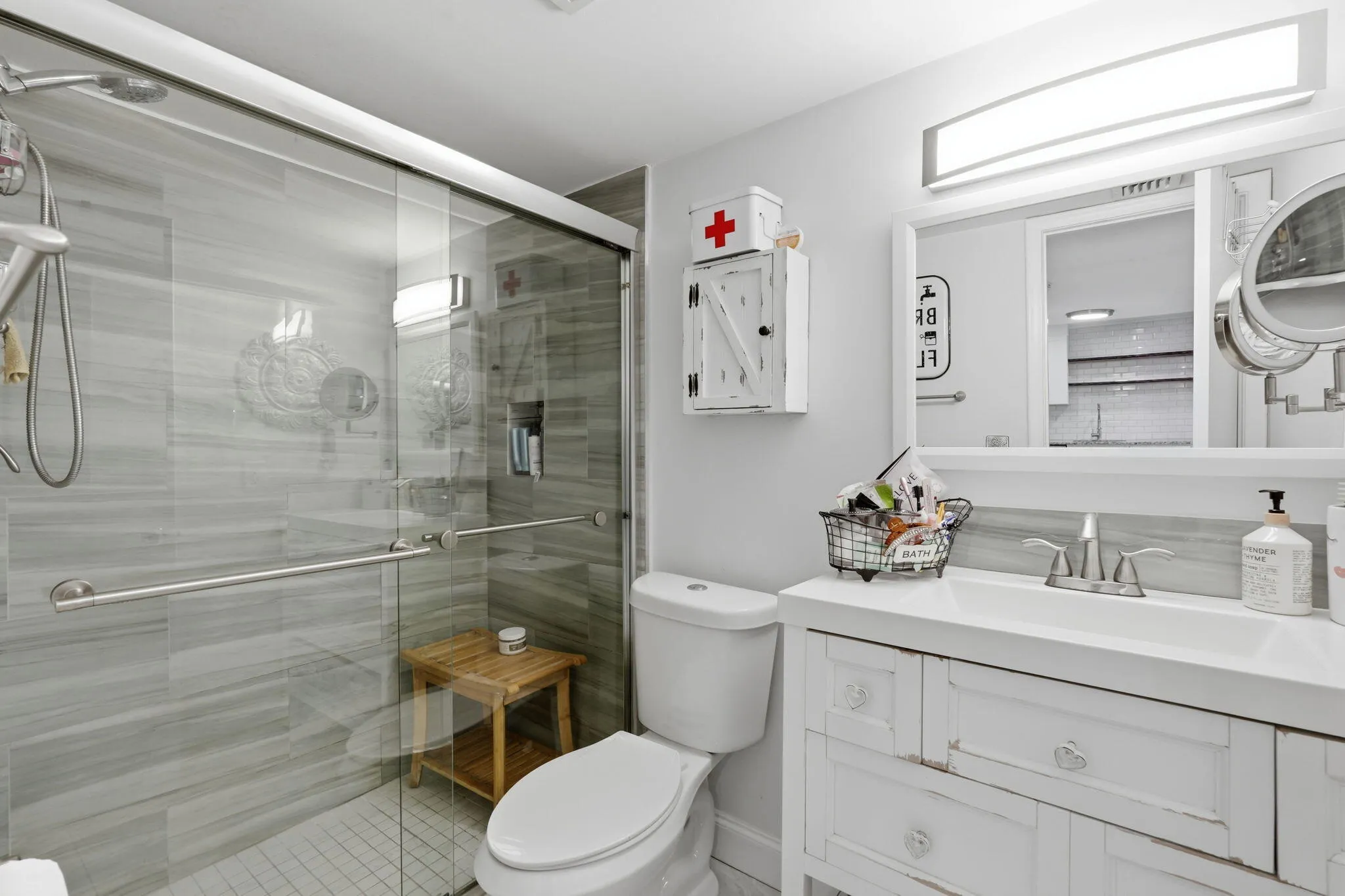 Glass-enclosed shower with horizontal tile surround and tiled floor