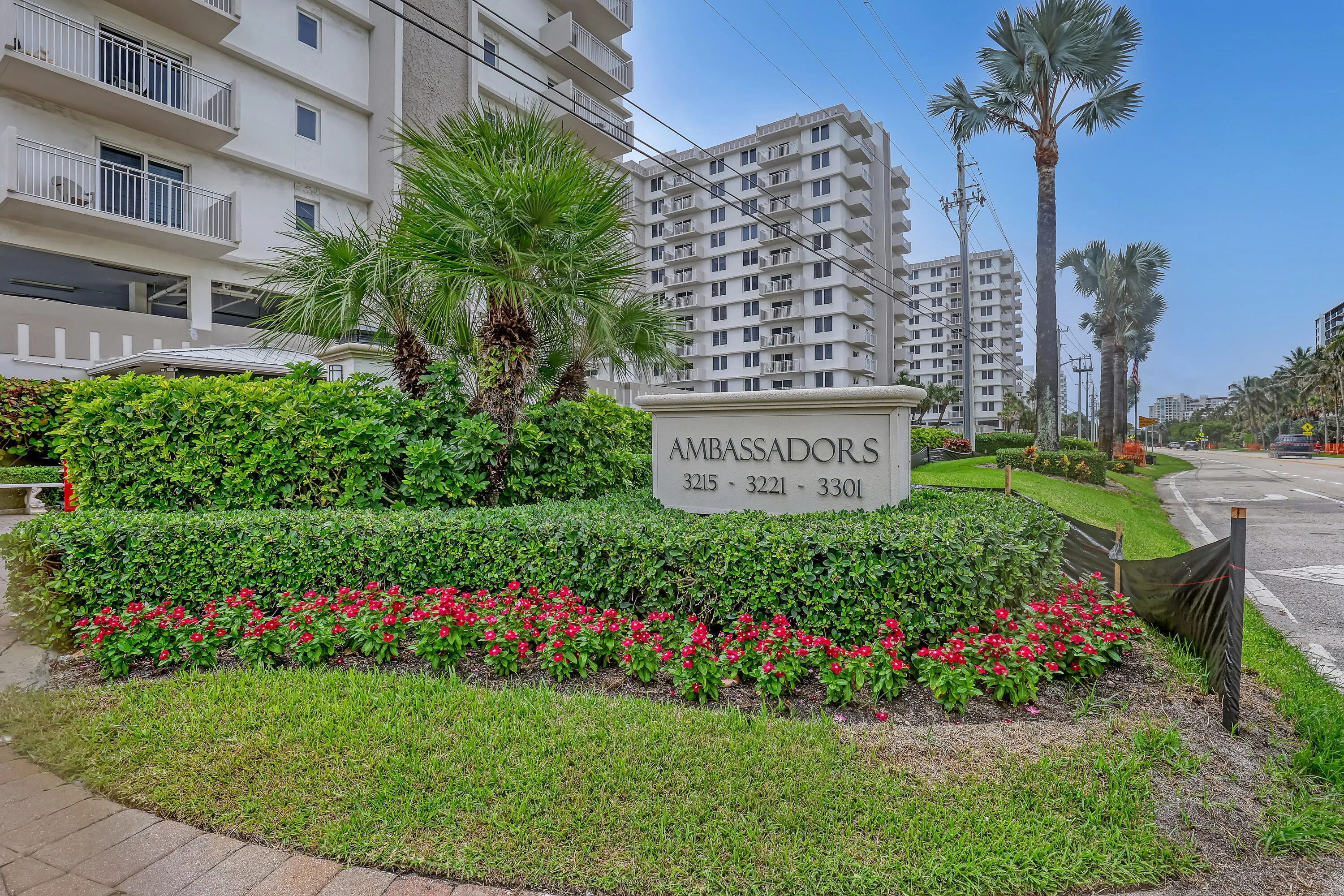 Paved walkway leading to a landscaped entrance with a stone monument sign