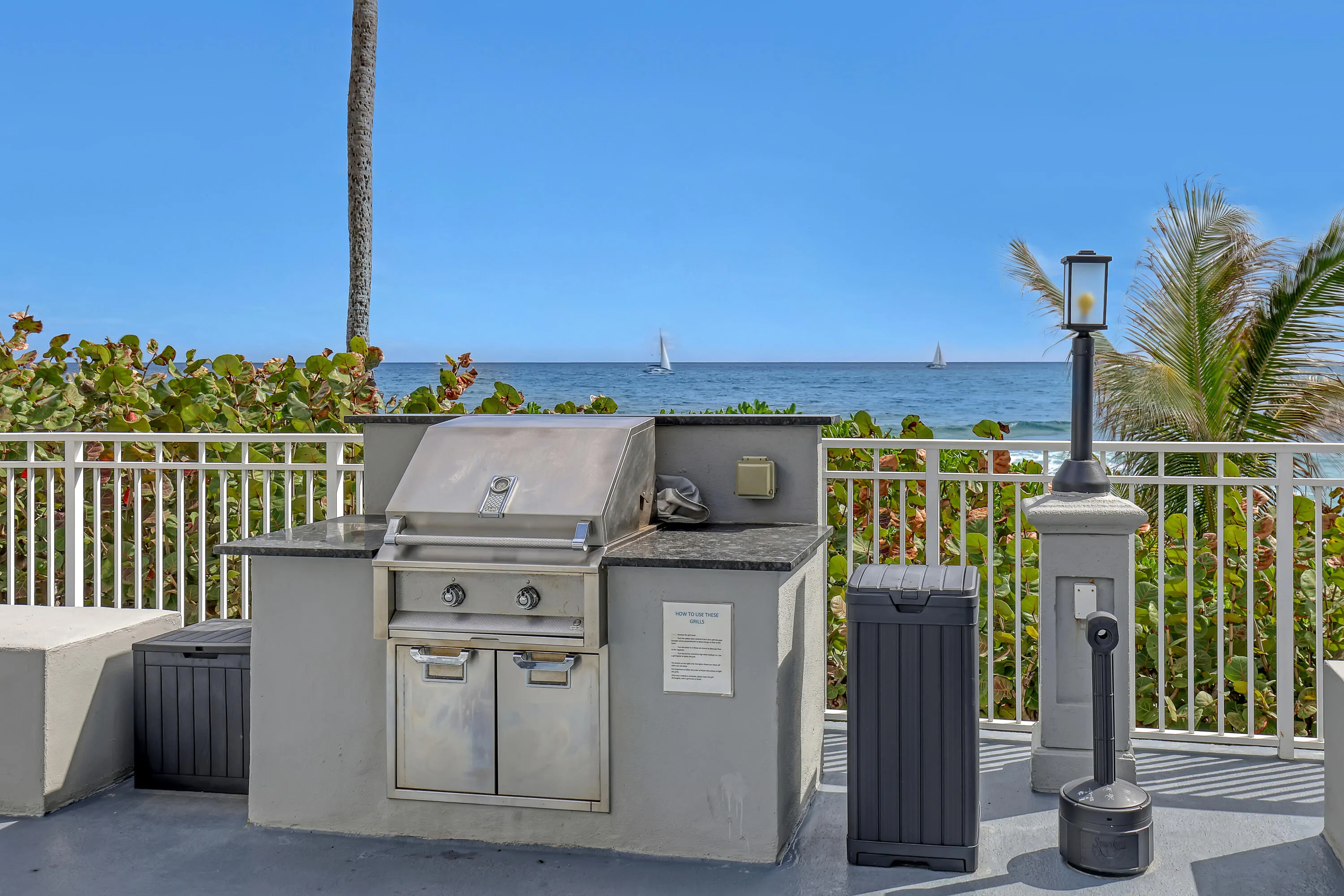 Outdoor grilling station featuring a built-in stainless steel grill, ample counter space, and a protective railing