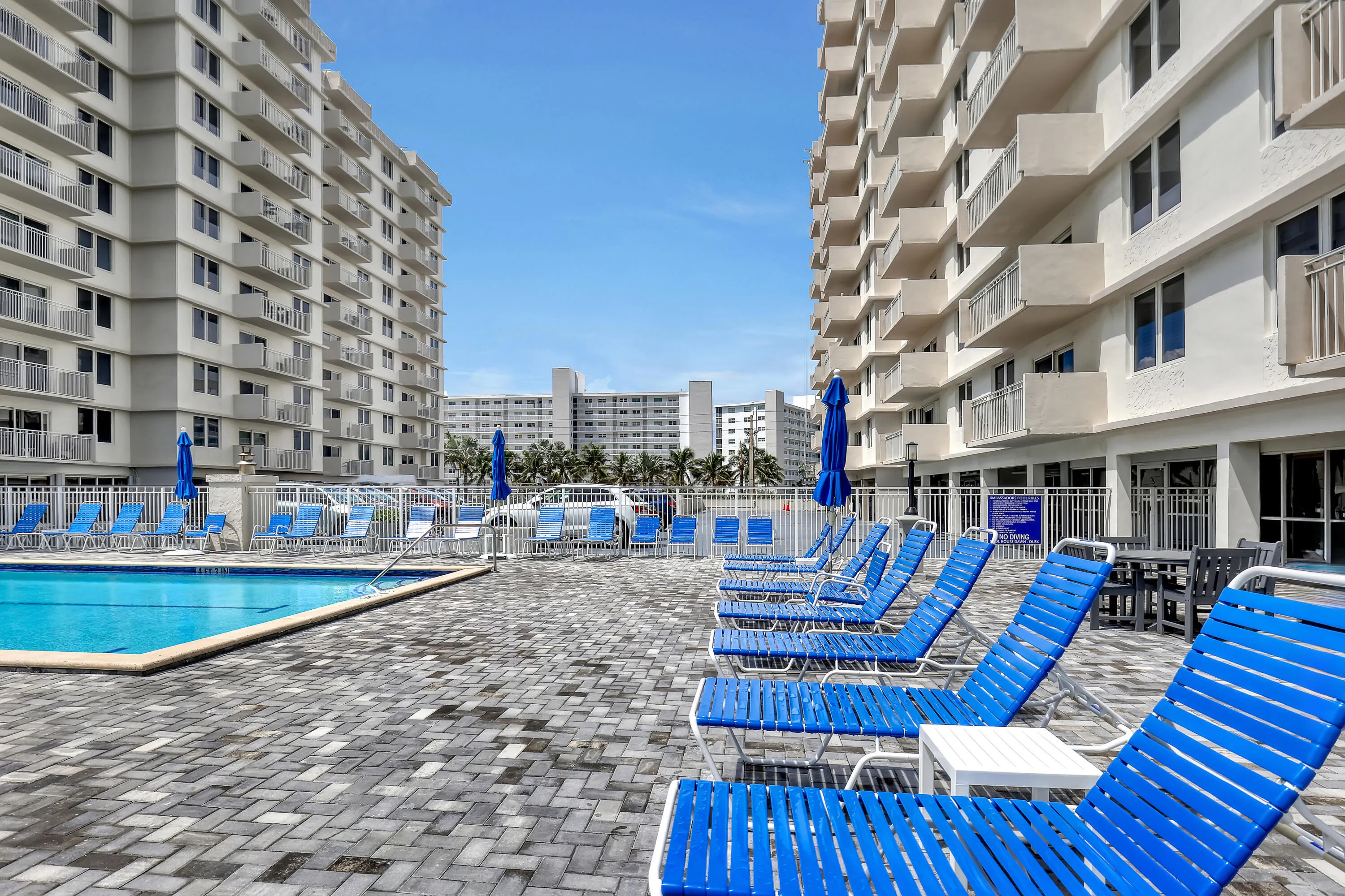 Outdoor swimming pool with integrated steps, surrounded by a paver patio