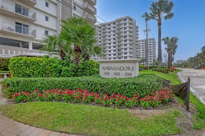 Paved walkway leading to a landscaped entrance with a stone monument sign