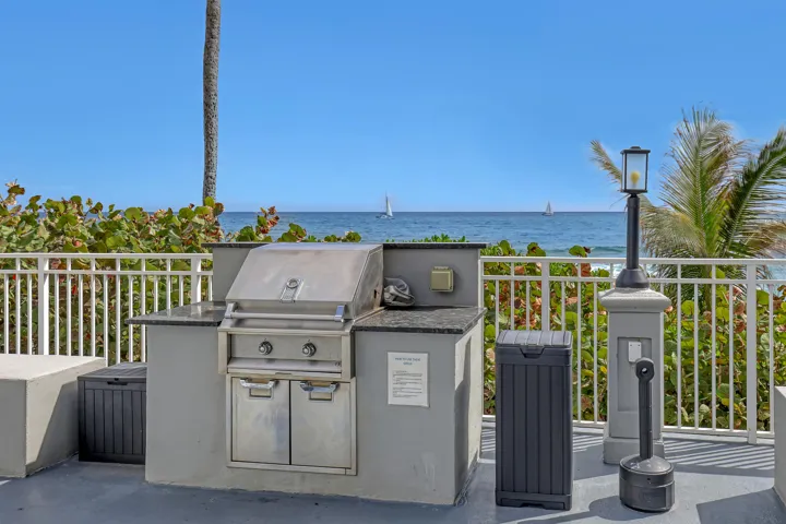 Outdoor grilling station featuring a built-in stainless steel grill, ample counter space, and a protective railing