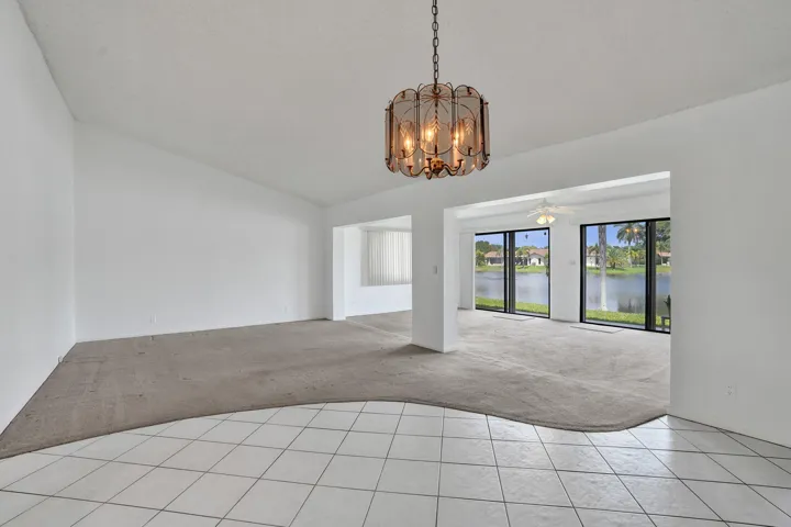Recessed lighting, large format tile flooring, carpeted living area, lakefront exposure, and glass sliding doors