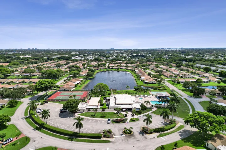 Community with central lake, tennis courts, and swimming pool