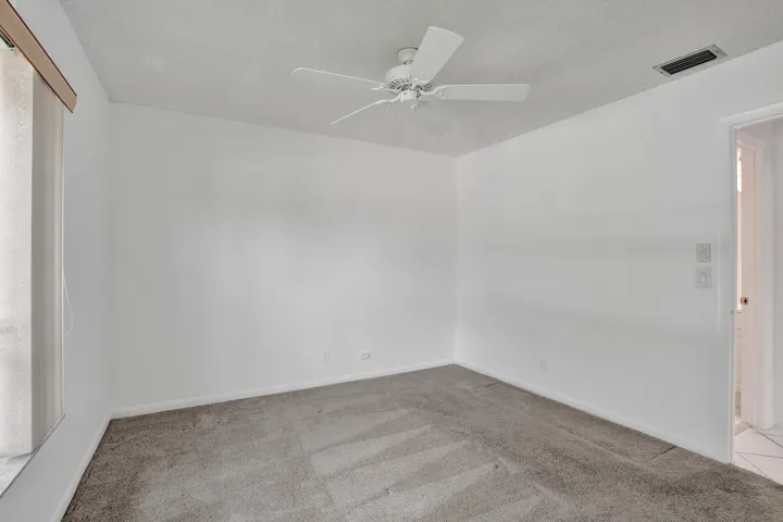 Ceiling fan with light kit, textured ceiling, wall-to-wall carpeting, window with blinds