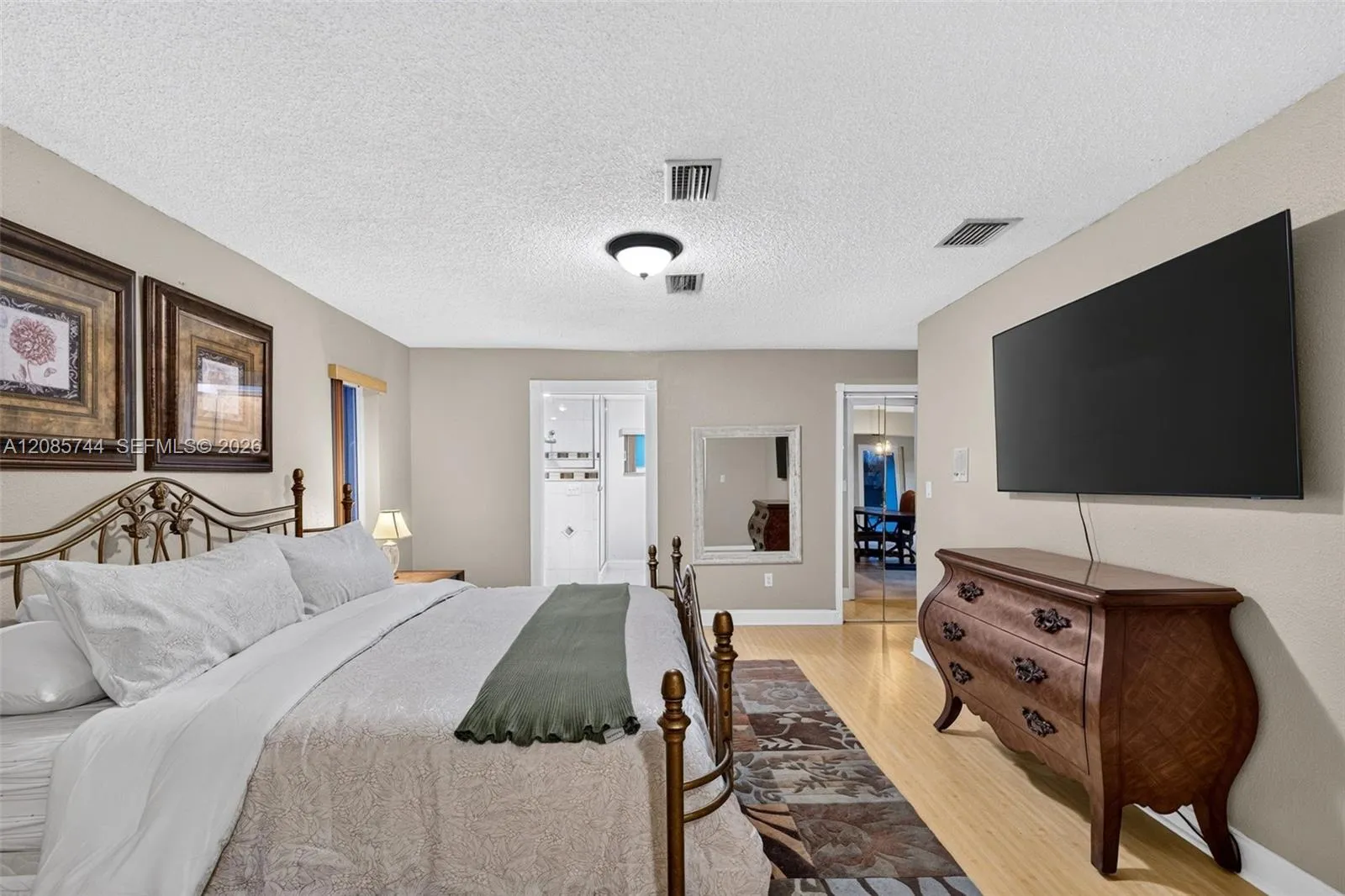 Oversized Primary bedroom w/ sitting area / office / library / nursery / gym add on (behind photographer). View toward ensuite bathroom & walk in closet. Laminate floors Oversized Primary bedroom w/ sitting area / office / library / nursery / gym add on (behind photographer). View toward ensuite bathroom & walk in closet. Laminate floors