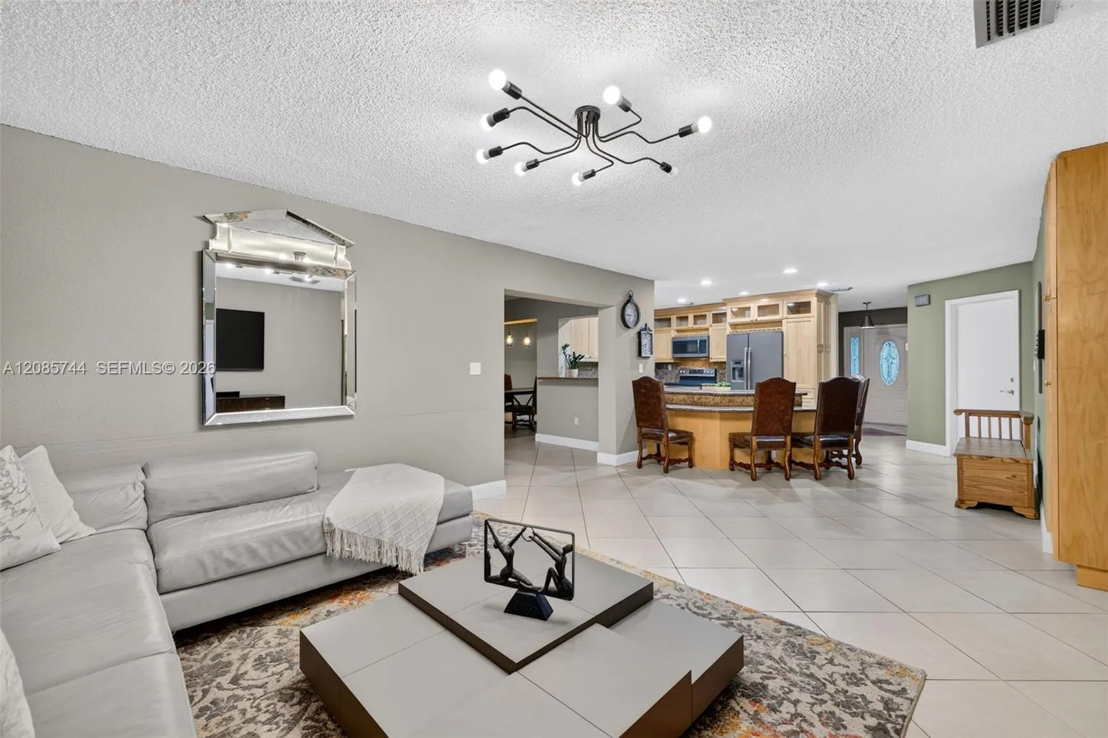 Bright family room / open concept great room – tile on diagonal, two bedrooms split to the right, primary beyond the kitchen to the left. Great floorplan Bright family room / open concept great room - tile on diagonal, two bedrooms split to the right, primary beyond the kitchen to the left. Great floorplan
