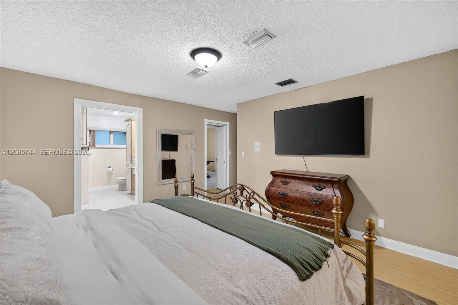 Oversized Primary bedroom w/ sitting area / office / library / nursery / gym add on (behind photographer). View toward ensuite bathroom & walk in closet. Laminate floors Oversized Primary bedroom w/ sitting area / office / library / nursery / gym add on (behind photographer). View toward ensuite bathroom & walk in closet. Laminate floors