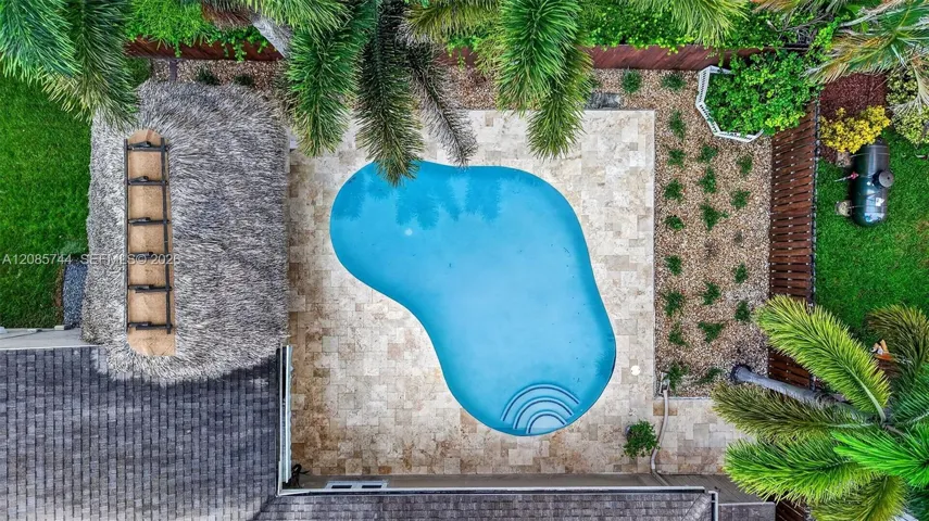 Gorgeous recently resurfaced pool w/ travertine decking, fully fenced, w/ amazing tiki hut, recently rethatched and new sprinkler pump