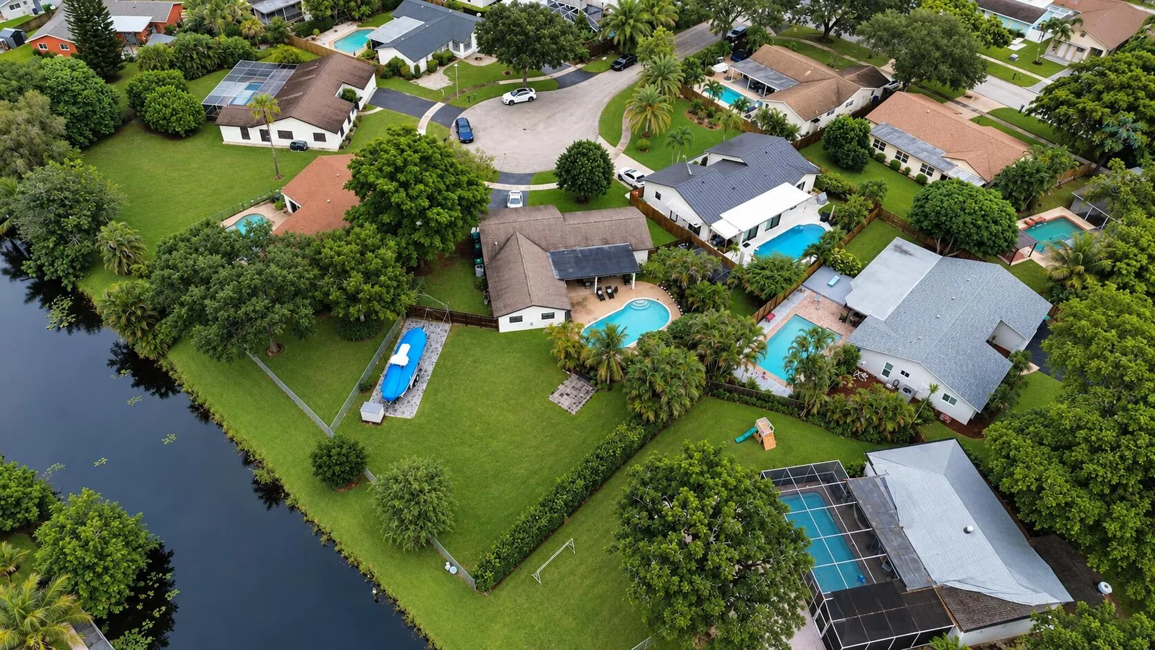 Expansive property featuring a canal, mature trees, and a private pool