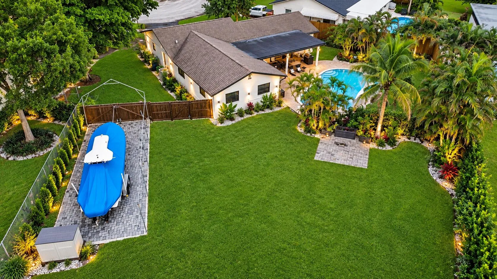 Spacious backyard with a freeform pool, paved patio, and mature landscaping