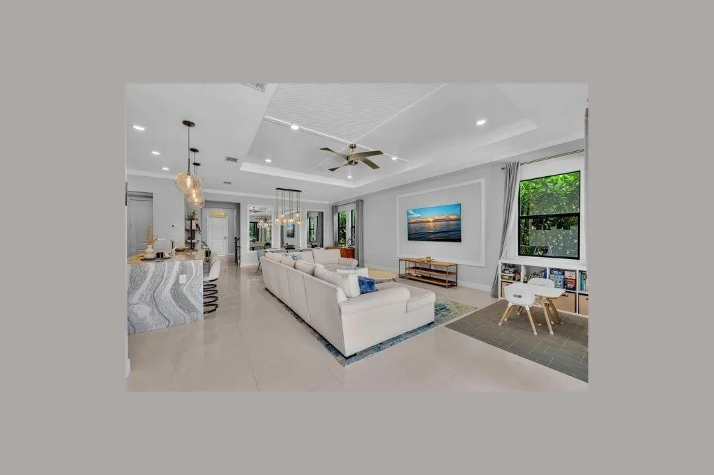 Spacious open-concept living area featuring a tray ceiling with recessed lighting and a ceiling​​‌​​​​‌​​‌‌​‌‌​​​‌‌​‌​‌​‌​​​‌​​ fan