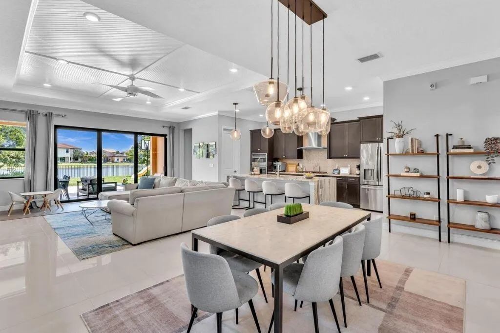 Open-concept interior featuring large format tile flooring and a tray ceiling with recessed lighting