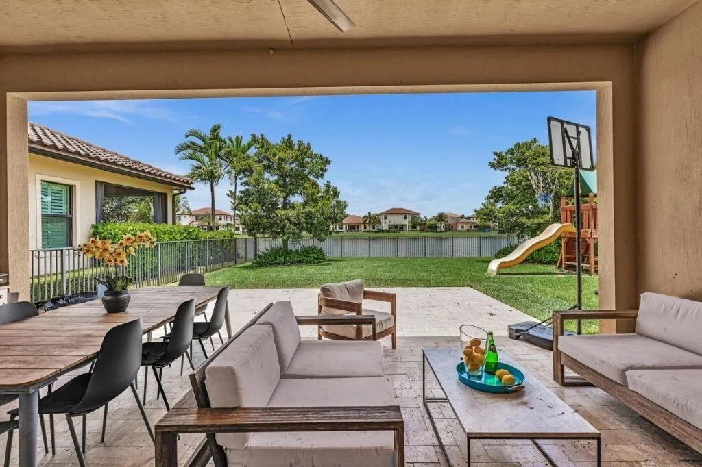 Covered outdoor patio with a ceiling fan, featuring a tile floor and substantial open space