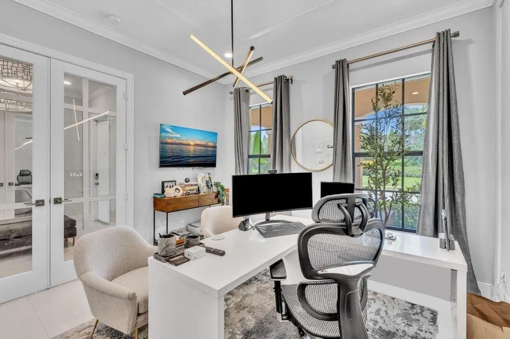 Bright room featuring double French doors with glass panels, a modern linear chandelier, and two large windows with dark frames