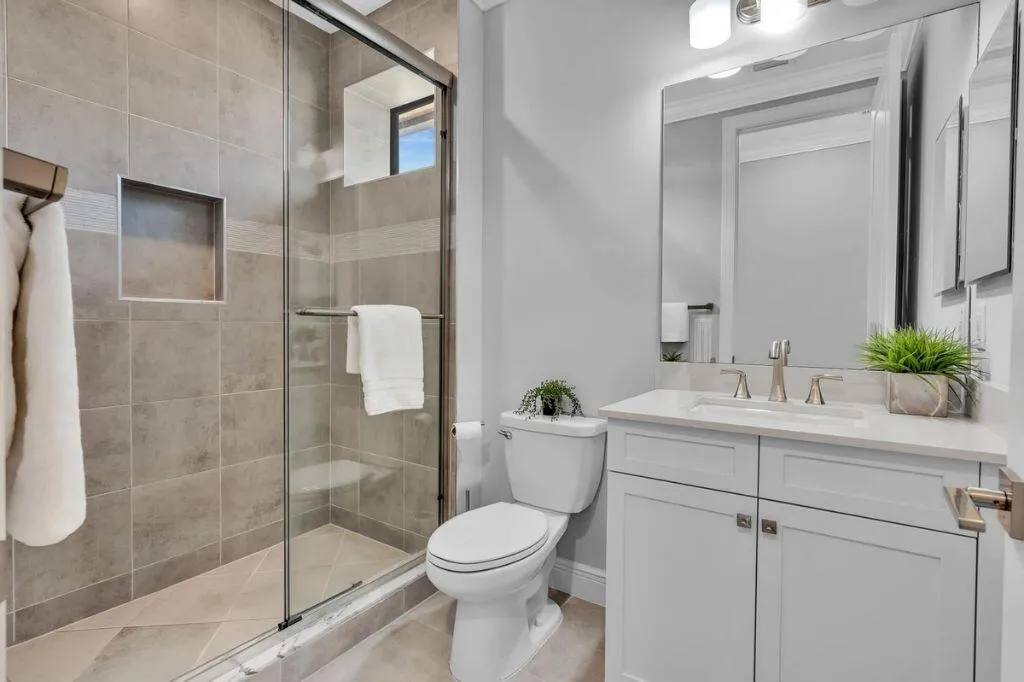 Bathroom featuring a glass-enclosed shower with tile surround and built-in niche