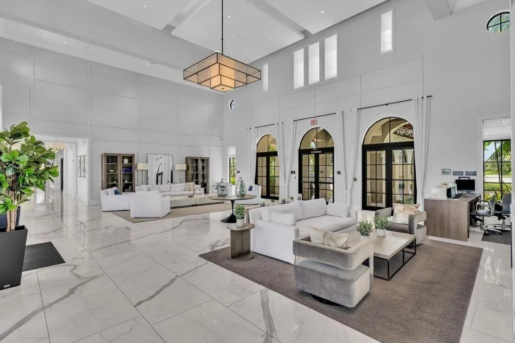 Spacious entry featuring high ceilings, large format tile flooring, and multiple arched glass doors