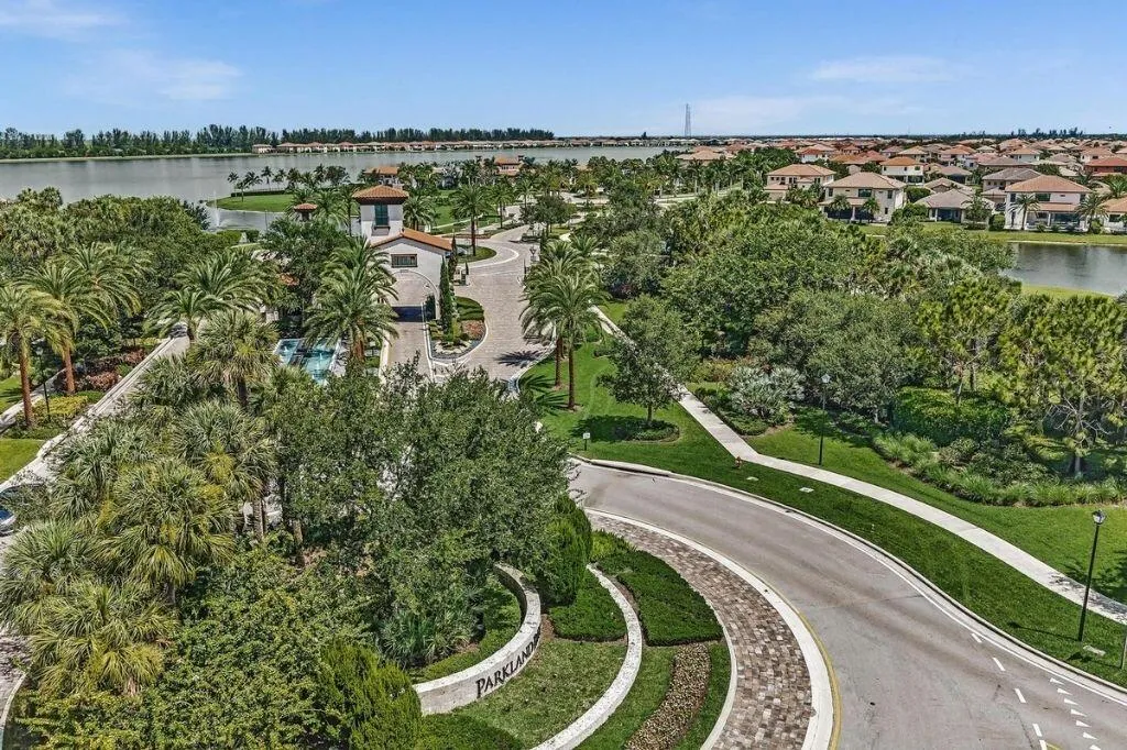 Aerial perspective highlighting a residential community entrance with a Mediterranean-style gatehouse