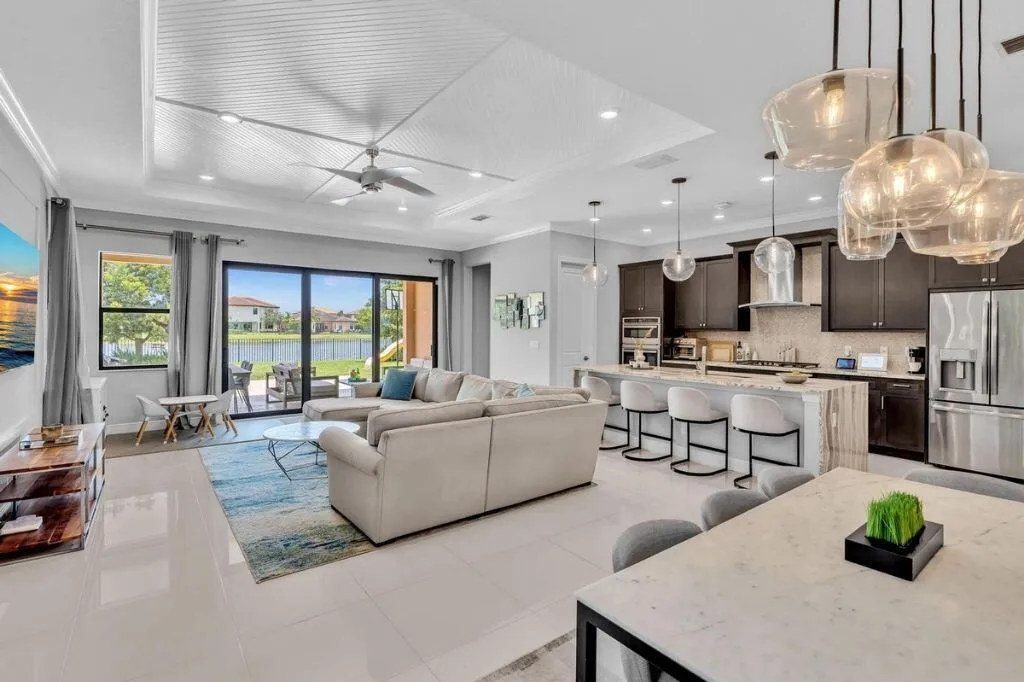 Open-concept living area featuring a coffered ceiling, recessed lighting, and large format floor tiles