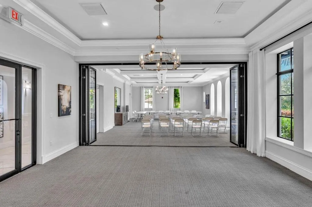 Spacious interior room featuring carpeted flooring and a multi-pane glass folding door system