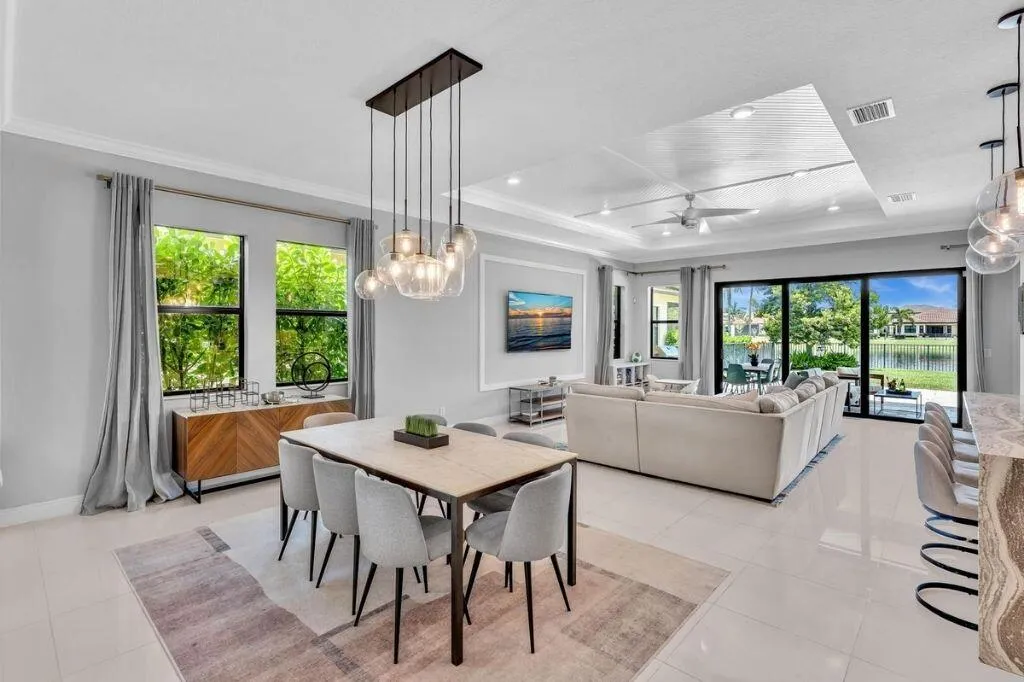 Open-concept living space featuring high ceilings with recessed lighting, large format tile flooring, and sliding glass doors