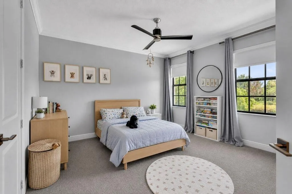 Spacious room featuring light gray walls, crown molding, and gray carpet