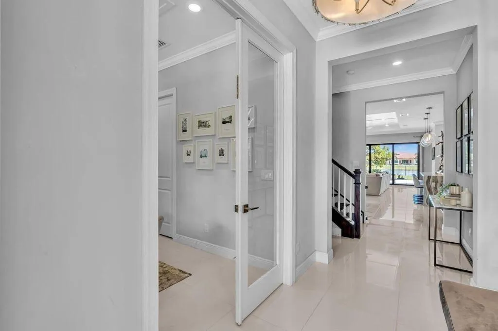 Foyer featuring polished tile flooring, recessed lighting, a staircase with dark wood-finish handrails and white balusters, and an arched entry to the main living area