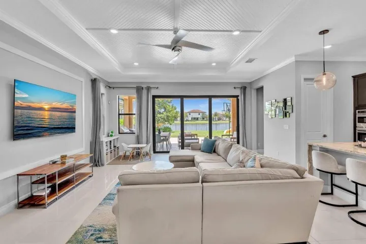 Spacious interior with tile flooring, a coffered ceiling, and a ceiling fan