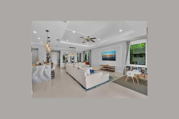 Spacious open-concept living area featuring a tray ceiling with recessed lighting and a ceiling​​‌​​​​‌​​‌‌​‌‌​​​‌‌​‌​‌​‌​​​‌​​ fan