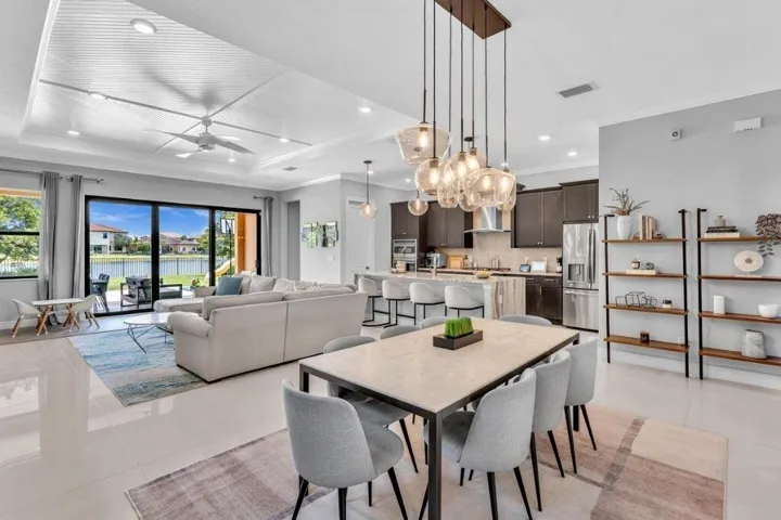 Open-concept interior featuring large format tile flooring and a tray ceiling with recessed lighting