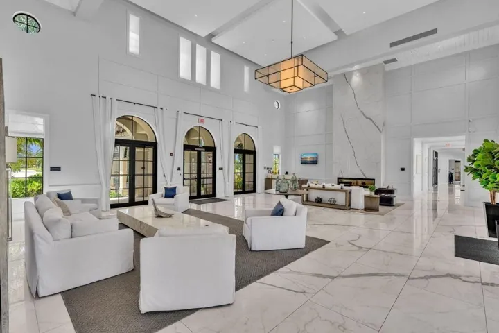 Spacious lobby featuring vaulted ceilings, a large-format geometric chandelier, and extensive marble-look flooring