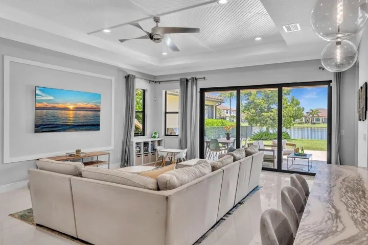 Spacious living area featuring large sliding glass doors opening to the patio and waterfront