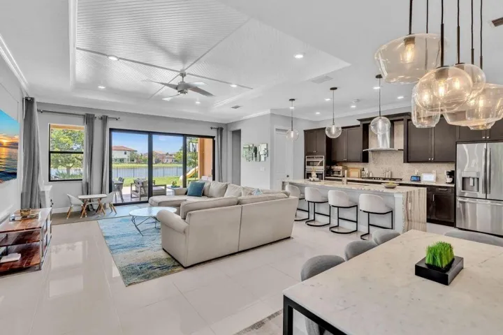 Open-concept living area featuring a coffered ceiling, recessed lighting, and large format floor tiles