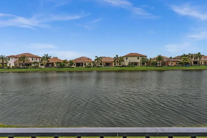 Waterfront properties featuring tile roofs and mature palm trees