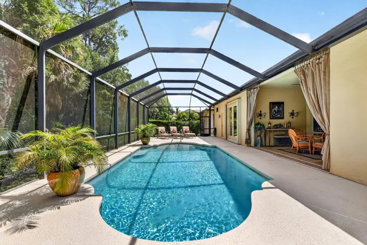 Screened-in outdoor pool with a curved edge and integrated steps