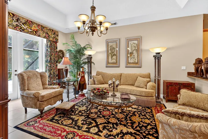 Glass-paneled double doors, chandelier, tile flooring, and neutral wall tones