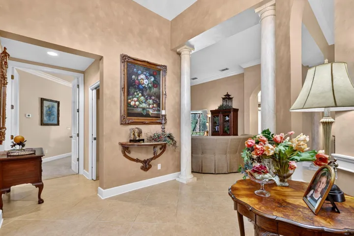 Tiled flooring, interior columns, high ceilings, arched doorways, and textured wall finishes