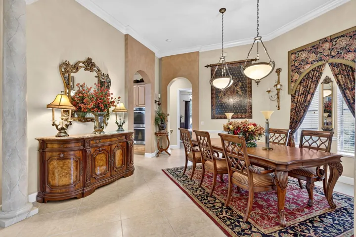 Formal dining area featuring tile flooring, vaulted ceilings, and two pendant light fixtures