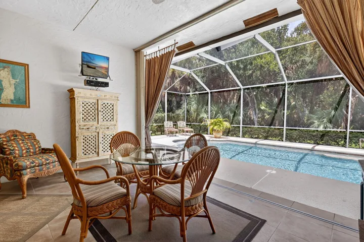Opening to a screened pool enclosure with a tiled patio