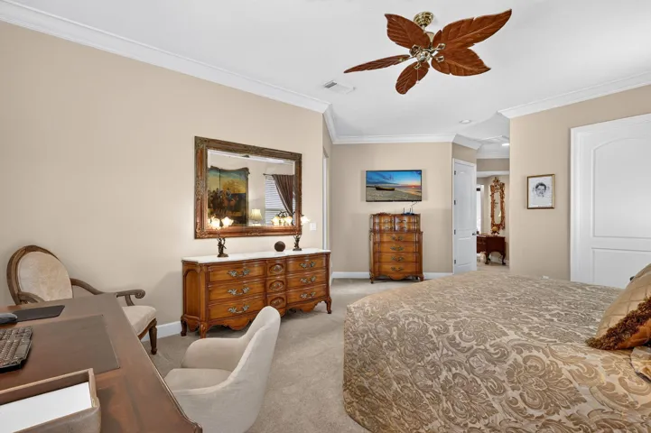 Crown molding, ceiling fan with wood-finish blades, and neutral wall paint