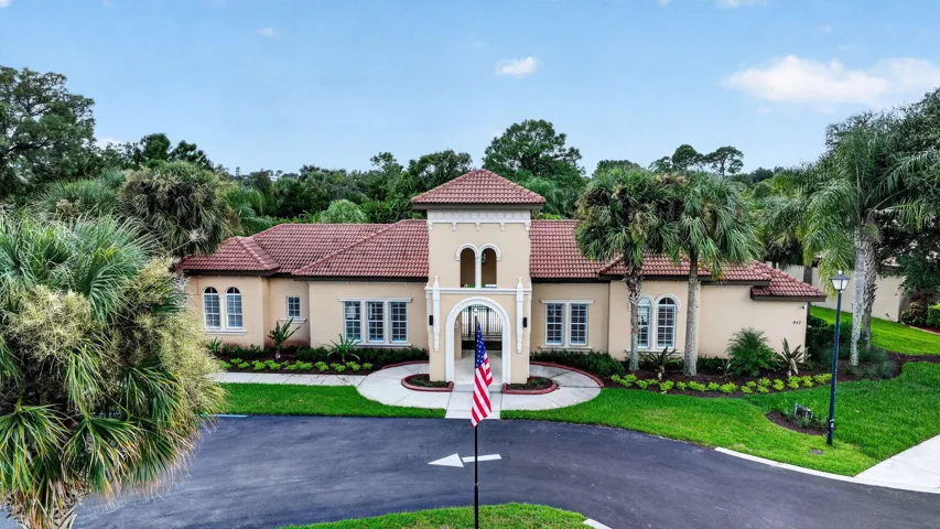 Mediterranean-style clubhouse with architecture with a tile roof, stucco exterior, and arched entry