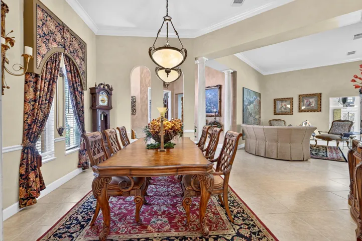 Dining, crown molding, wall sconces, arched doorways, and tile flooring