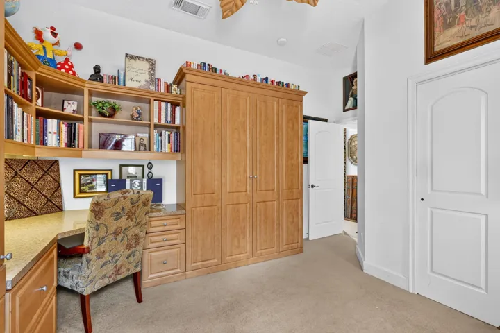 Built-in desk with a stone-finish countertop, integrated shelving, and cabinetry, and Murphy bed