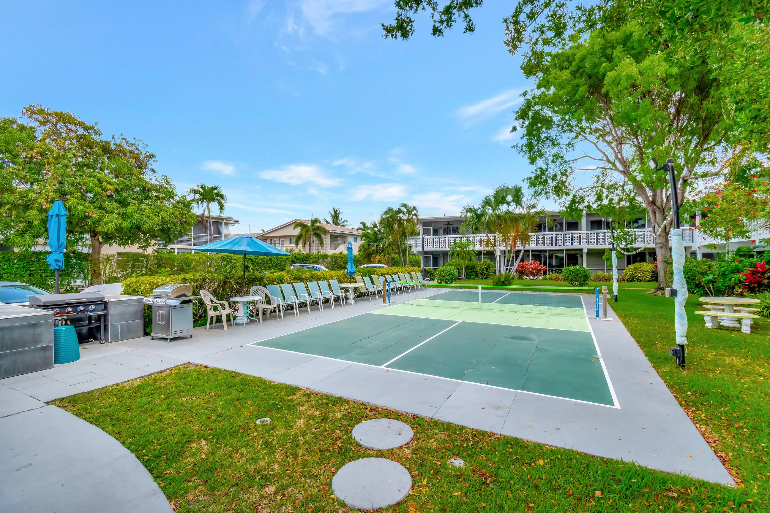 Pickleball court, paved patio, outdoor seating, barbecue grills, and manicured landscaping