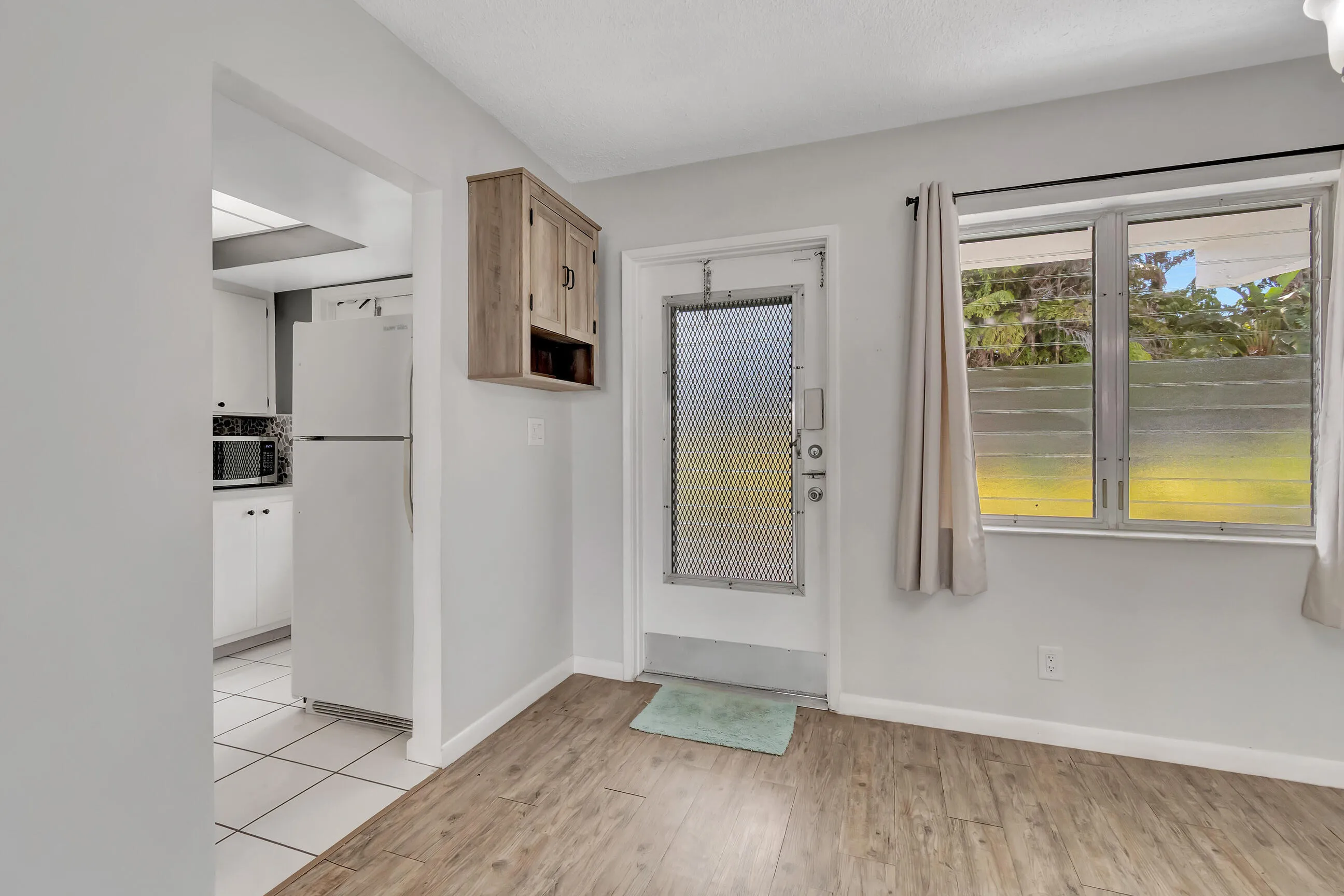 Kitchen with white cabinetry, white appliances, and a mosaic tile backsplash