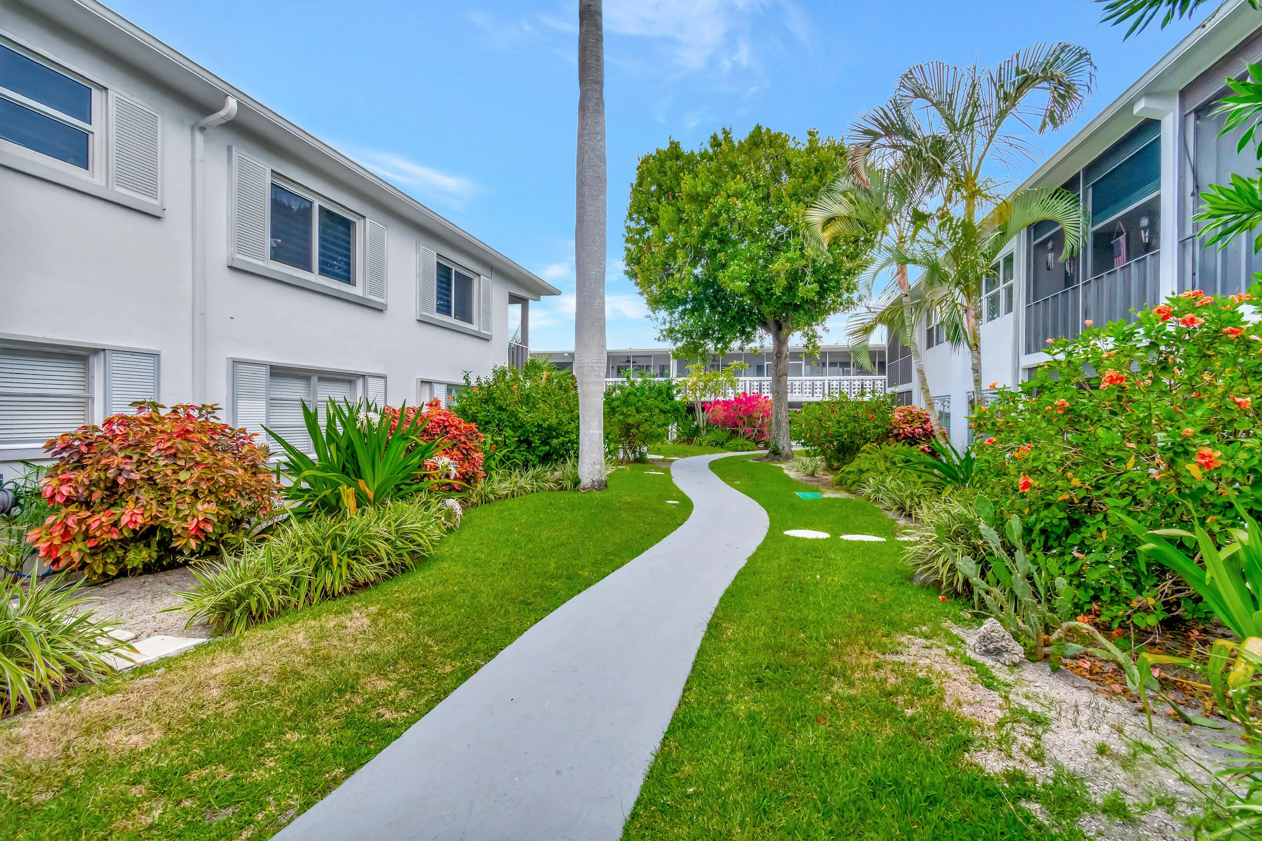 Lush landscaping with mature trees, established shrubs, and flowering plants